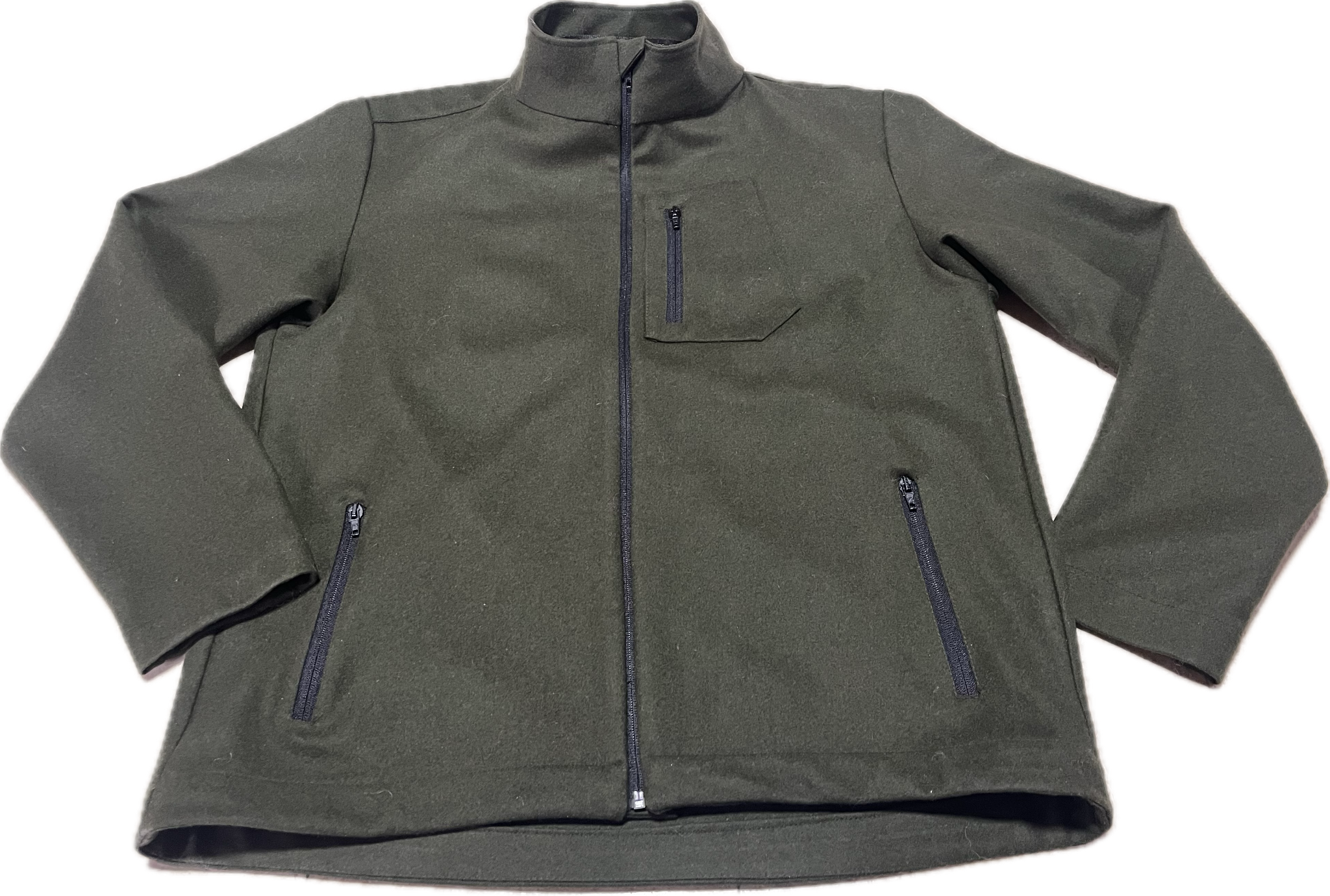 Roughstuff Leichtgaist leichte Lodenjacke für Alltag, Wandern und Outdoor-Aktivitäten. Dünne und angenehm zu tragende Jacke aus robuster Wollmischung mit sportlichem Schnitt, verstellbarem Bund und hoher Bewegungsfreiheit durch Rückenfalten. Ausgestattet mit seitlichen Taschen und Brusttasche, ideal als Zwischenschicht oder leichte Außenschicht bei mildem Wetter. Farbe Olivgrün