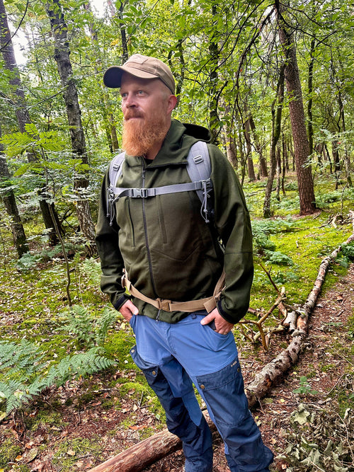 Roughstuff Bergteufel technische Lodenjacke für Outdoor, Trekking und Abenteuer bei jedem Wetter. Robuste Outdoorjacke mit sportlichem Schnitt, großer verstellbarer Kapuze, hohem Kragen und langen Belüftungsreißverschlüssen für optimalen Wind- und Wetterschutz. Ausgestattet mit großen Taschen, Raglanärmeln und funktionalen Details für maximale Bewegungsfreiheit beim Wandern, Radfahren und Bushcraft. Farbe Olivgrün