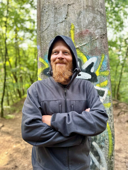 Roughstuff Bergteufel technische Lodenjacke für Outdoor, Trekking und Abenteuer bei jedem Wetter. Robuste Outdoorjacke mit sportlichem Schnitt, großer verstellbarer Kapuze, hohem Kragen und langen Belüftungsreißverschlüssen für optimalen Wind- und Wetterschutz. Ausgestattet mit großen Taschen, Raglanärmeln und funktionalen Details für maximale Bewegungsfreiheit beim Wandern, Radfahren und Bushcraft. Farbe Anthrazit