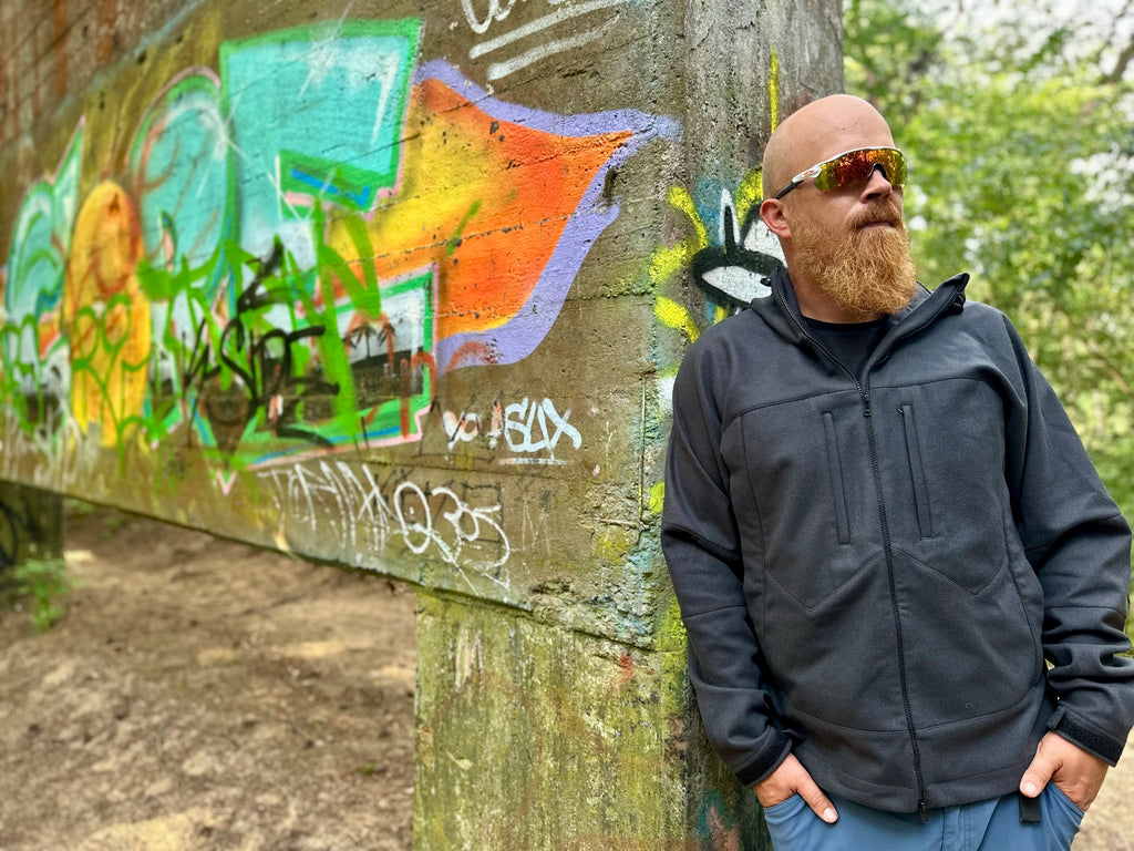 Roughstuff Bergteufel technische Lodenjacke für Outdoor, Trekking und Abenteuer bei jedem Wetter. Robuste Outdoorjacke mit sportlichem Schnitt, großer verstellbarer Kapuze, hohem Kragen und langen Belüftungsreißverschlüssen für optimalen Wind- und Wetterschutz. Ausgestattet mit großen Taschen, Raglanärmeln und funktionalen Details für maximale Bewegungsfreiheit beim Wandern, Radfahren und Bushcraft. Farbe Anthrazit
